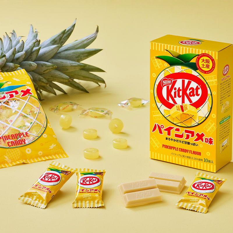Paquet de KitKat ananas entouré de décorations d'ananas et de bonbons Pine Ame, édition limitée Japon