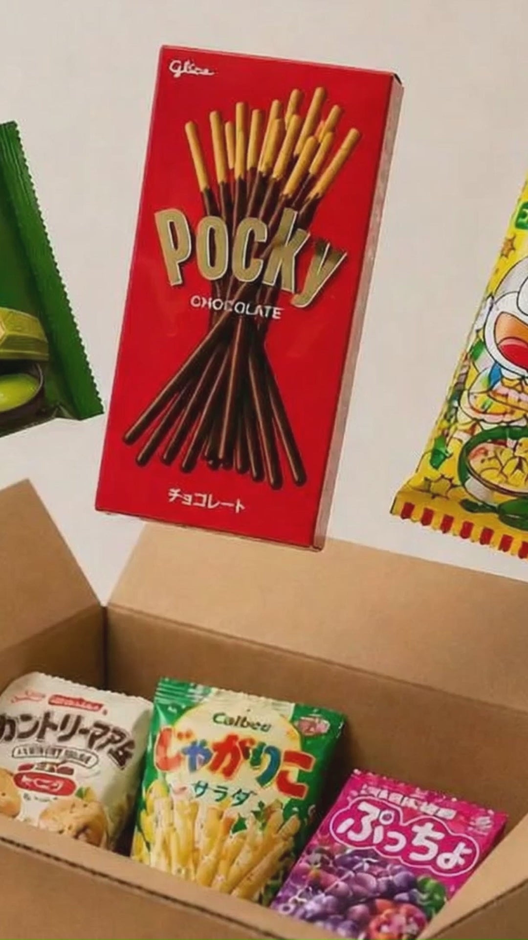 A cinematic video showing a snack box traveling from Japan through Tokyo and Kyoto, flying across the world to New York, where it is delivered to a family who open it and enjoy Japanese snacks together.